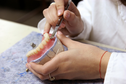 A dentist working on dentures | Same-Day Dentures in Indiana | Aegis Dental Group or Angola Dental Center